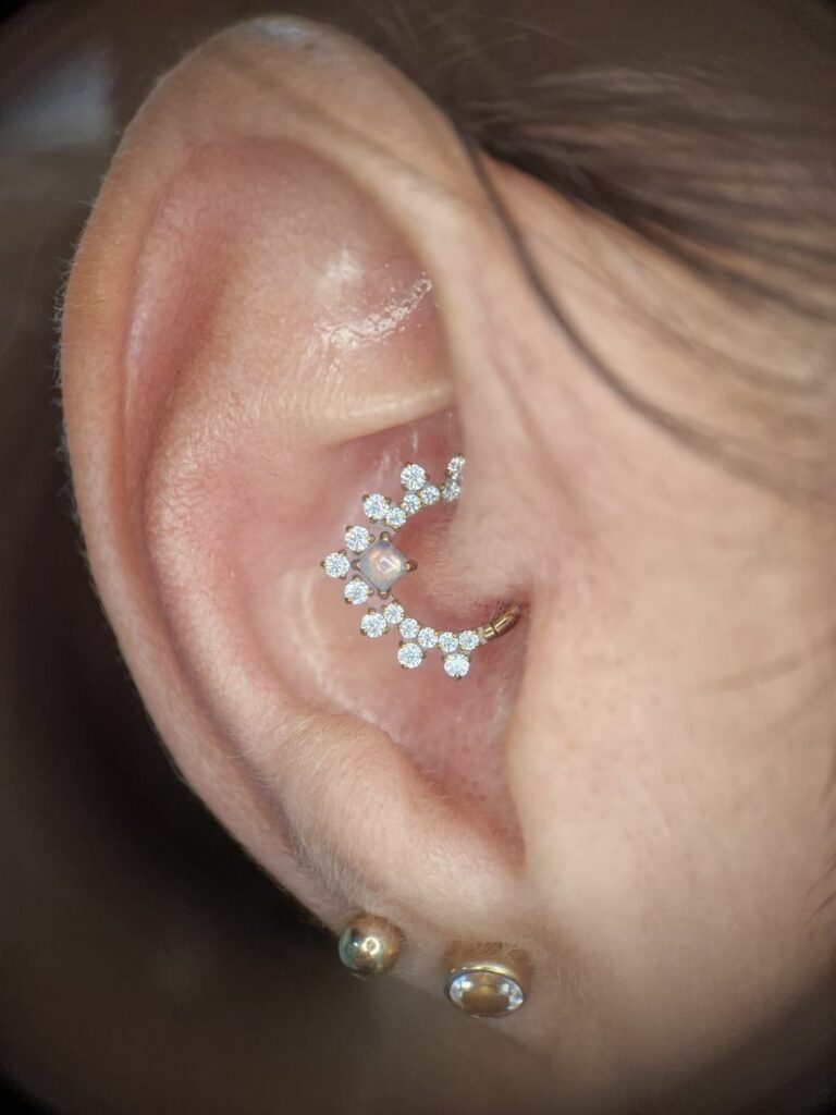 Piercing daith avec anneau couronne de zircons, réalisé par Oc Piercing au salon Jolie Piqûre à Arles