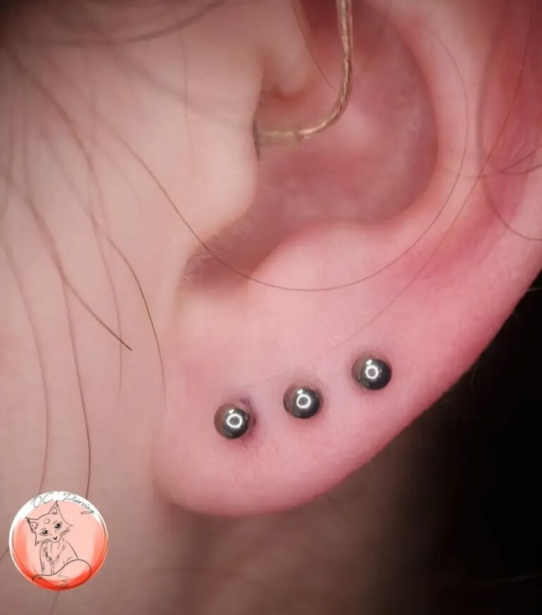 Triple piercing du lobe avec billes en titane, réalisé par Oc Piercing au salon Jolie Piqûre à Arles