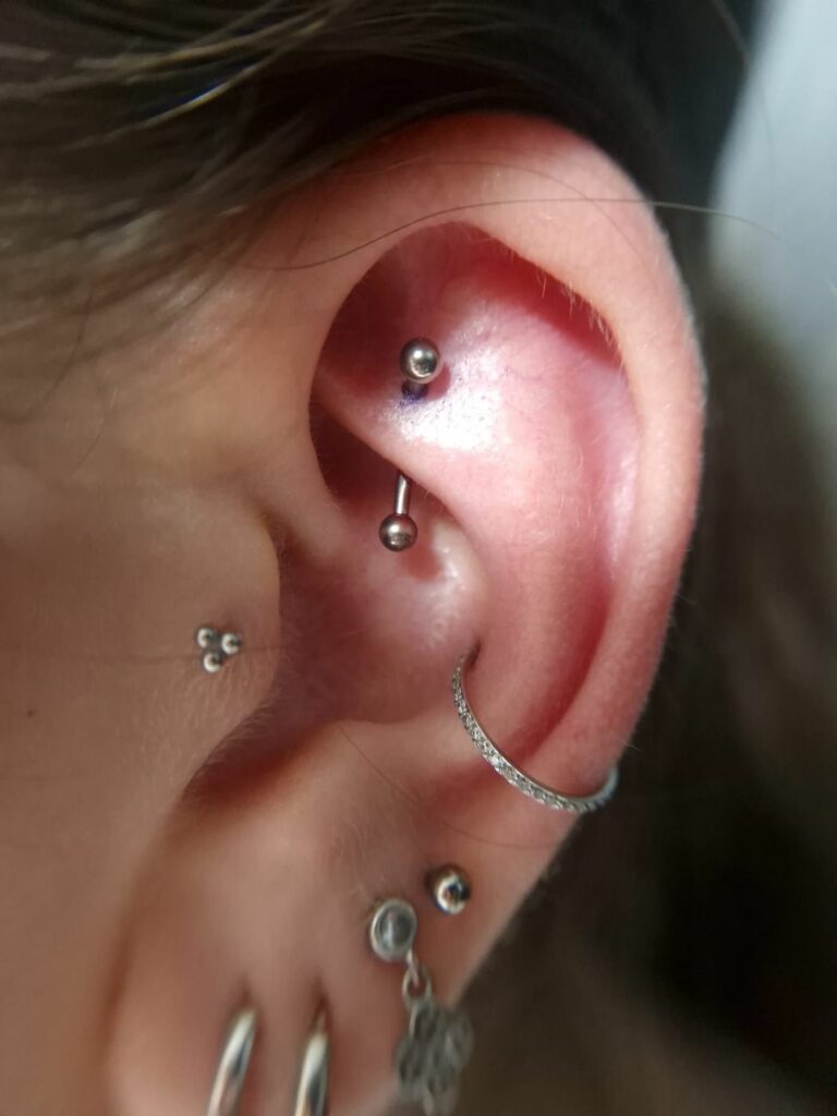Piercing rook dans le repli supérieur de l’oreille, barre courbe en titane, réalisé par Oc Piercing au salon Jolie Piqûre à Arles