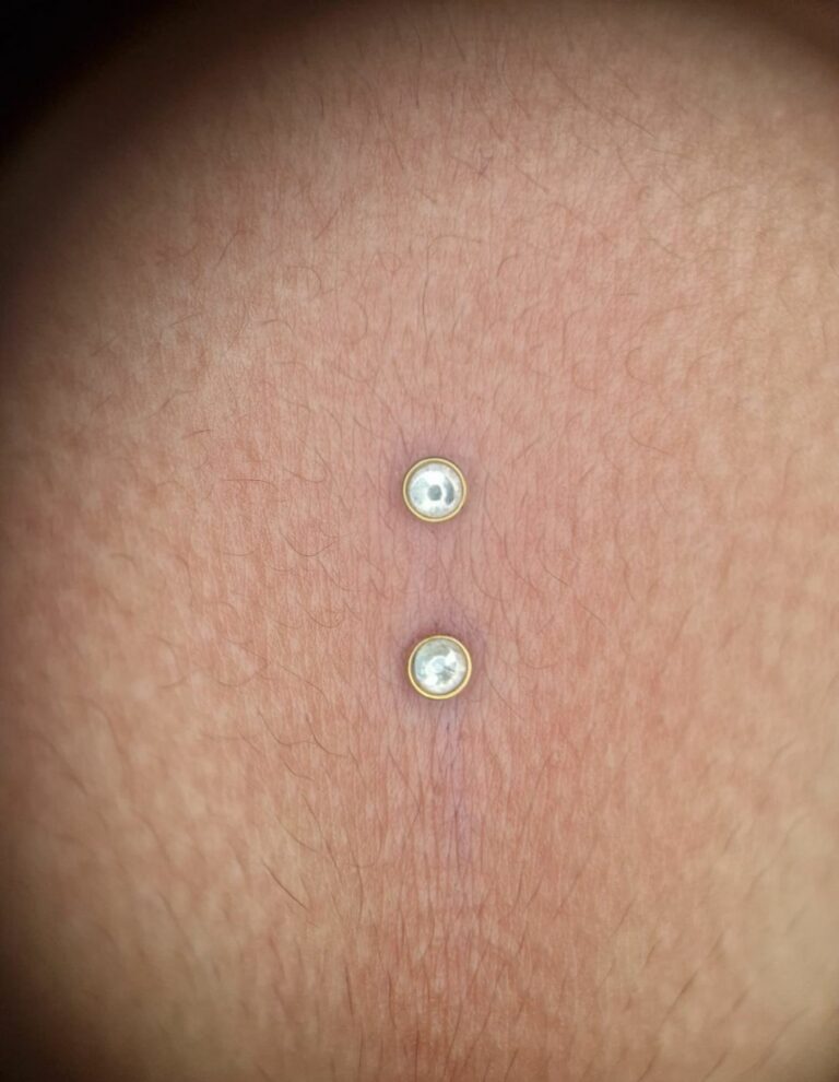 Piercing surface avec deux embouts perles, réalisé par Oc Piercing au salon Jolie Piqûre à Arles