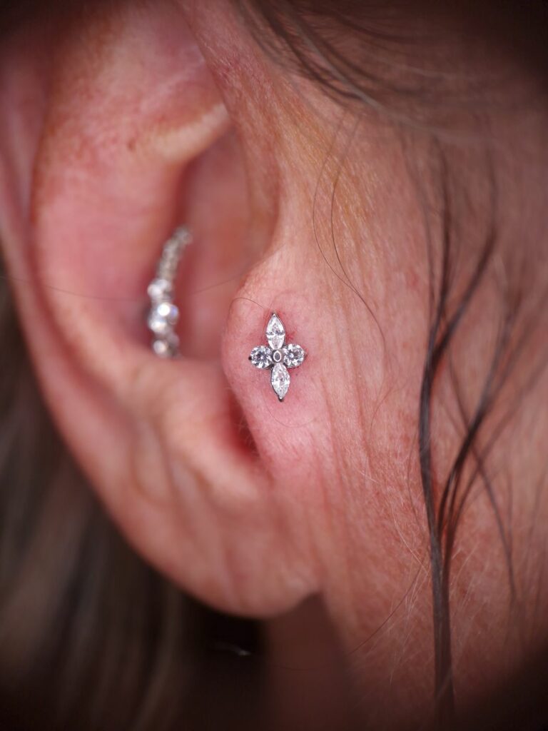 Piercing tragus avec embout fleur en zircons, réalisé par Oc Piercing au salon Jolie Piqûre à Arles